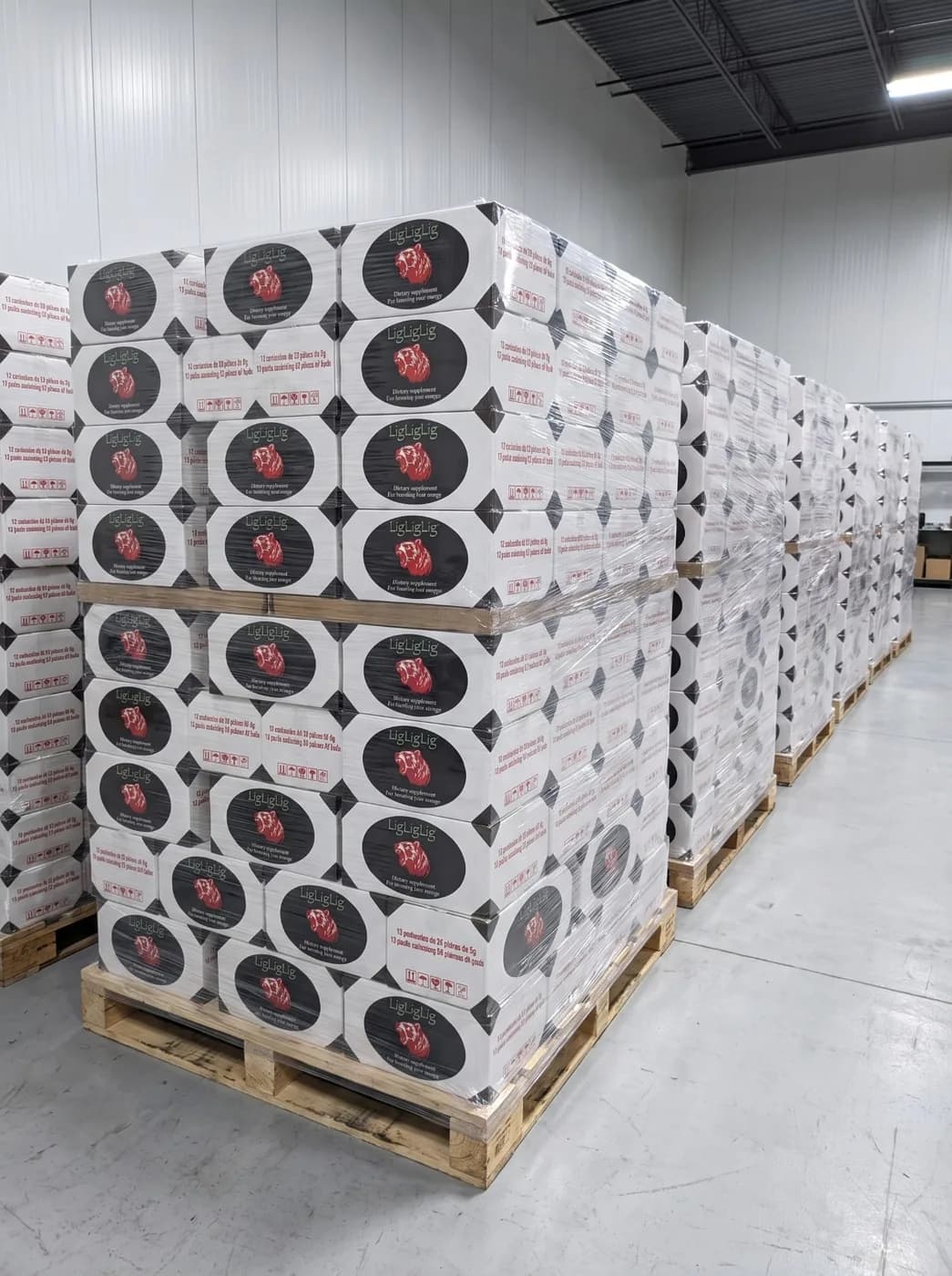 Pallets of LigLigLig dietary-supplement boxes, shrink-wrapped in a distribution warehouse